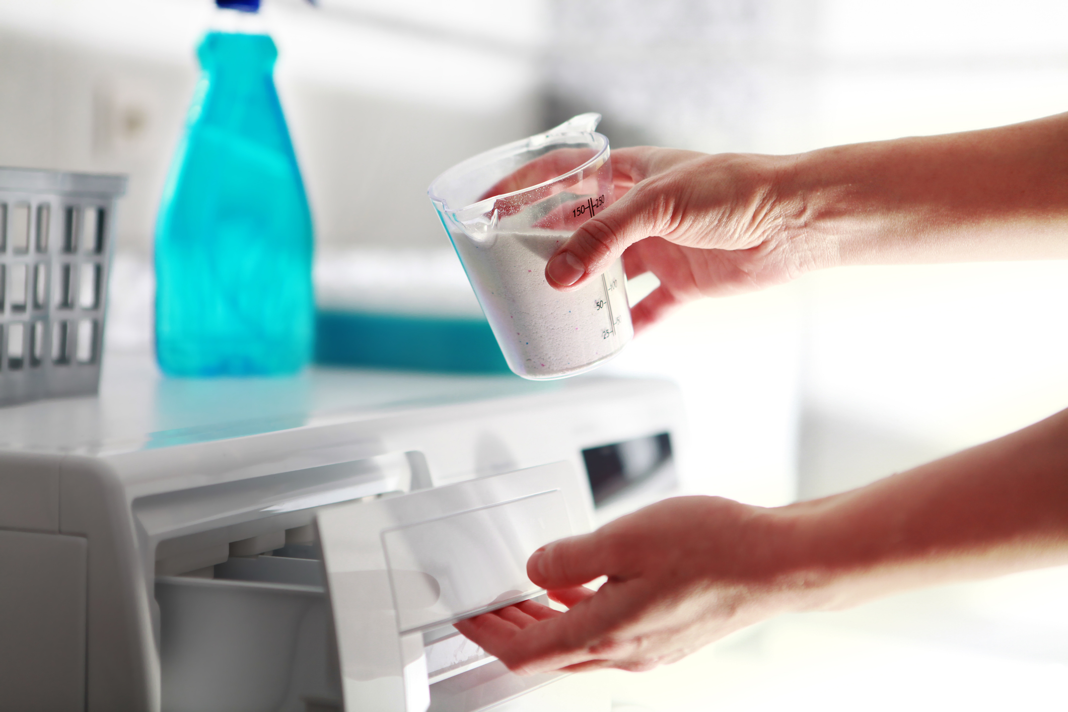 hand that fills detergent Ein Fensterreiniger säubert ein Fenster mit einem Abzieher.